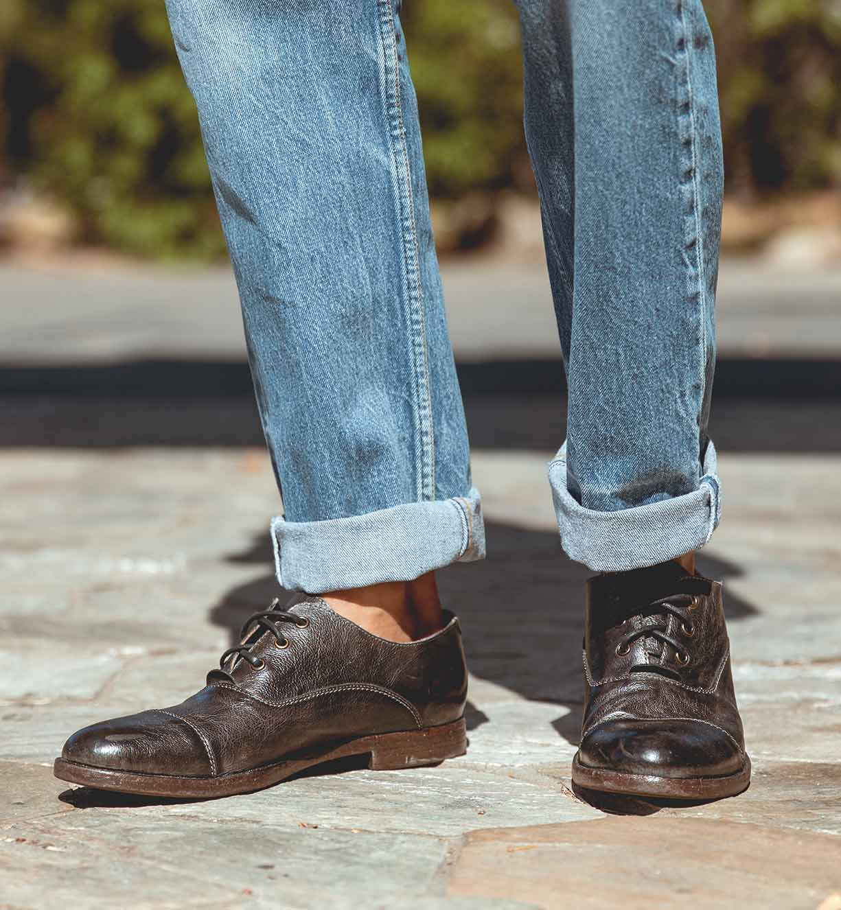A man wearing jeans and a pair of black Bed Stu Donatello oxford shoes.
