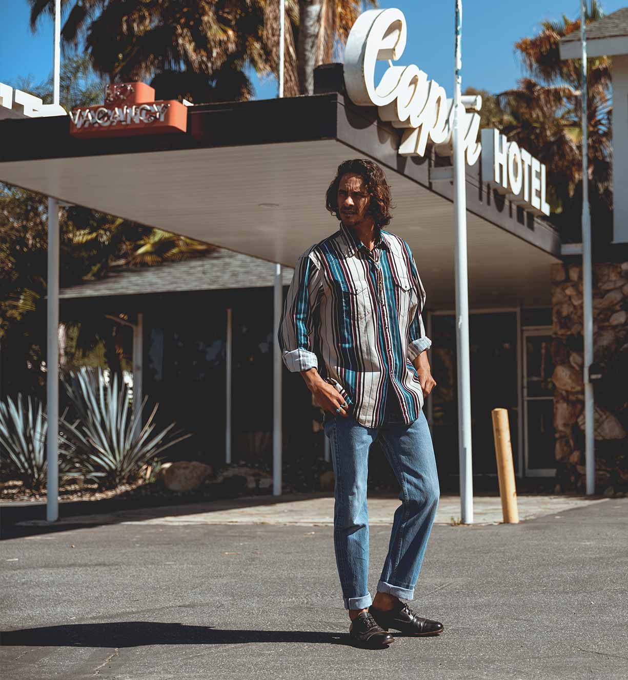 A man standing in front of a hotel wearing Donatello shoes from Bed Stu.