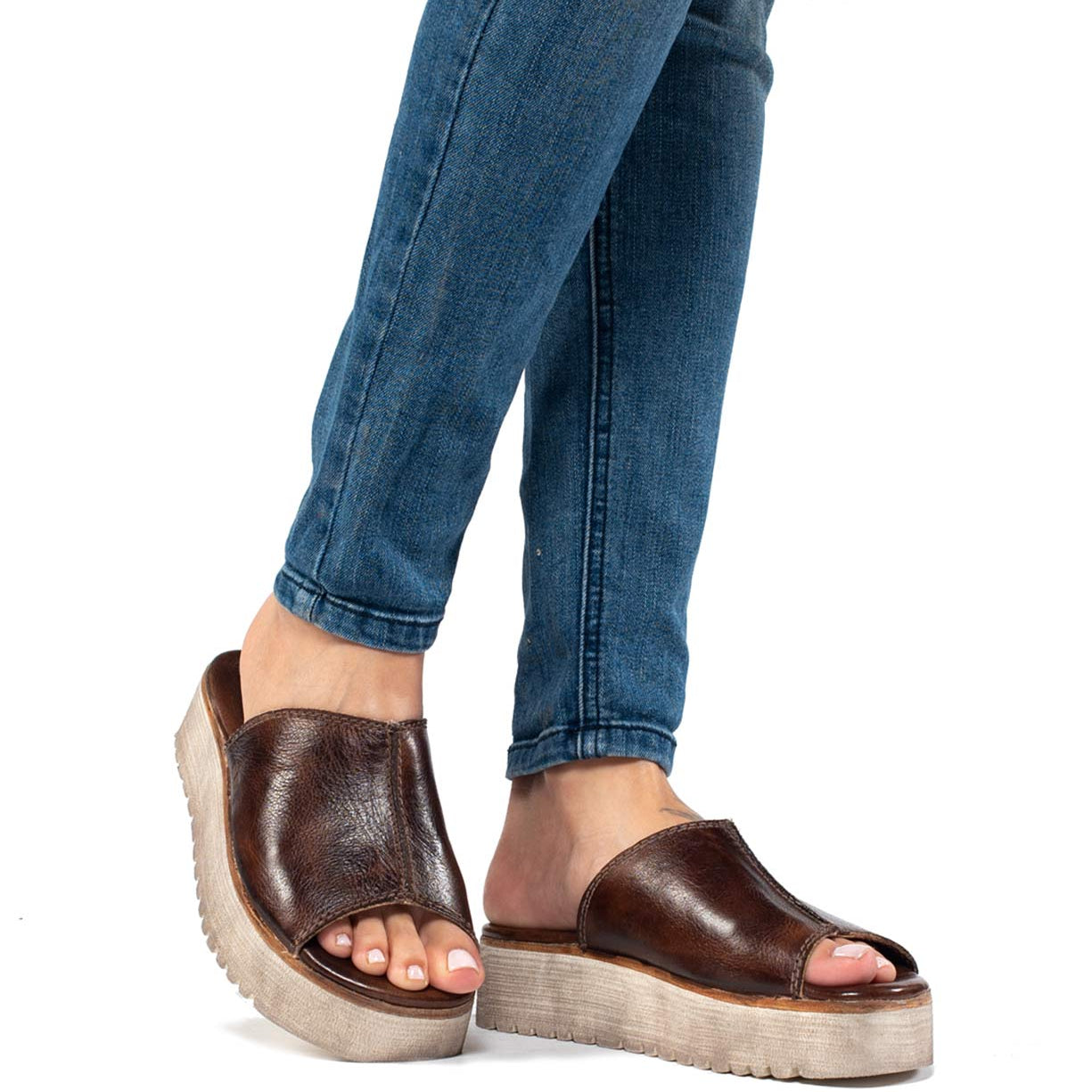 A woman's feet in a pair of brown Bed Stu Fairlee II platform sandals.