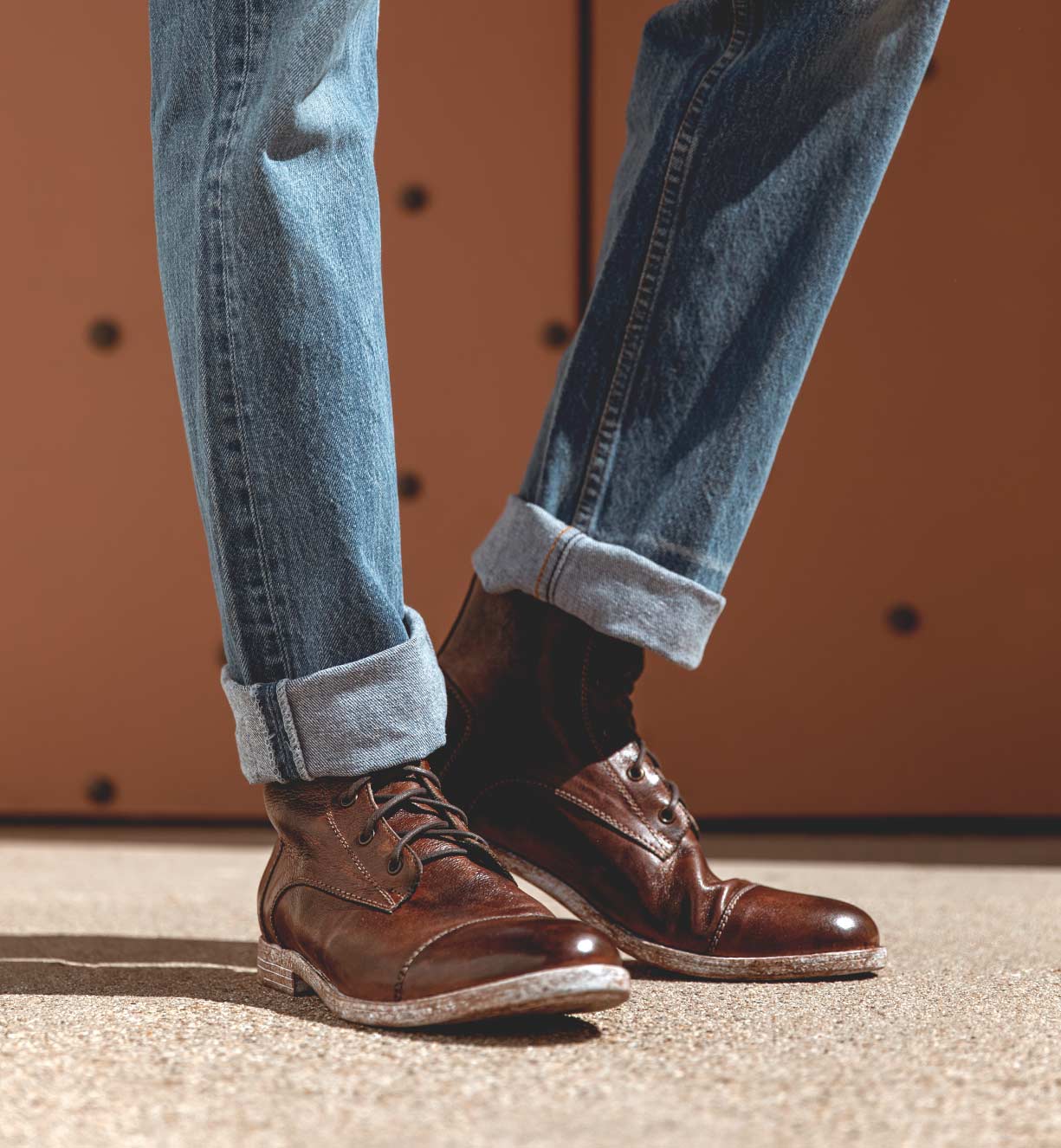 A man wearing jeans and a pair of Leonardo brown boots by Bed Stu.