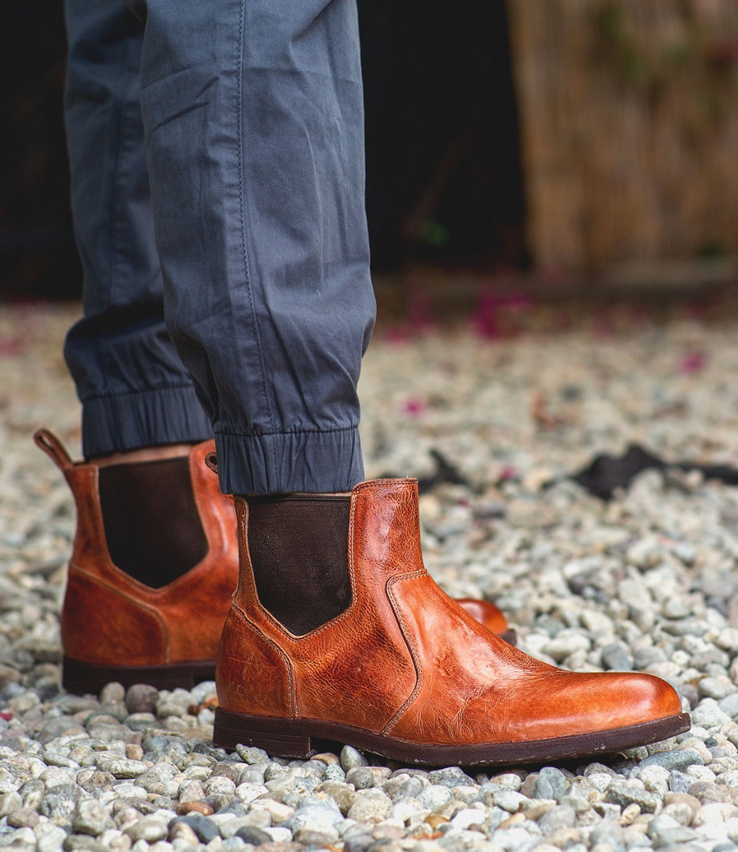 A man wearing a pair of brown Bed Stu Vasari chelsea boots.