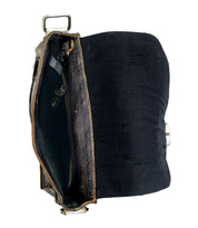 Side view of an open, Bed Stu Venice Beach II leather briefcase with a black fabric lining, featuring a checkered front panel, showing wear around the edges.