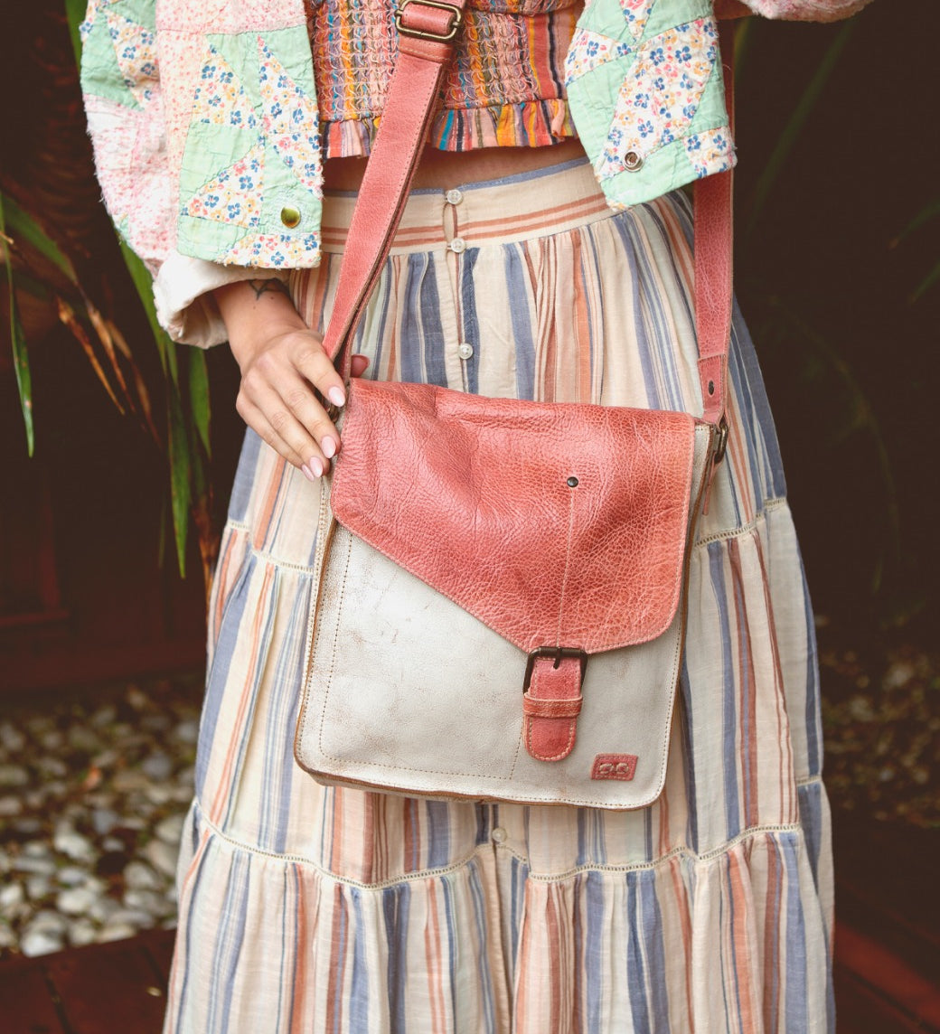 A woman in a striped skirt holding a Venice Beach bag by Bed Stu.