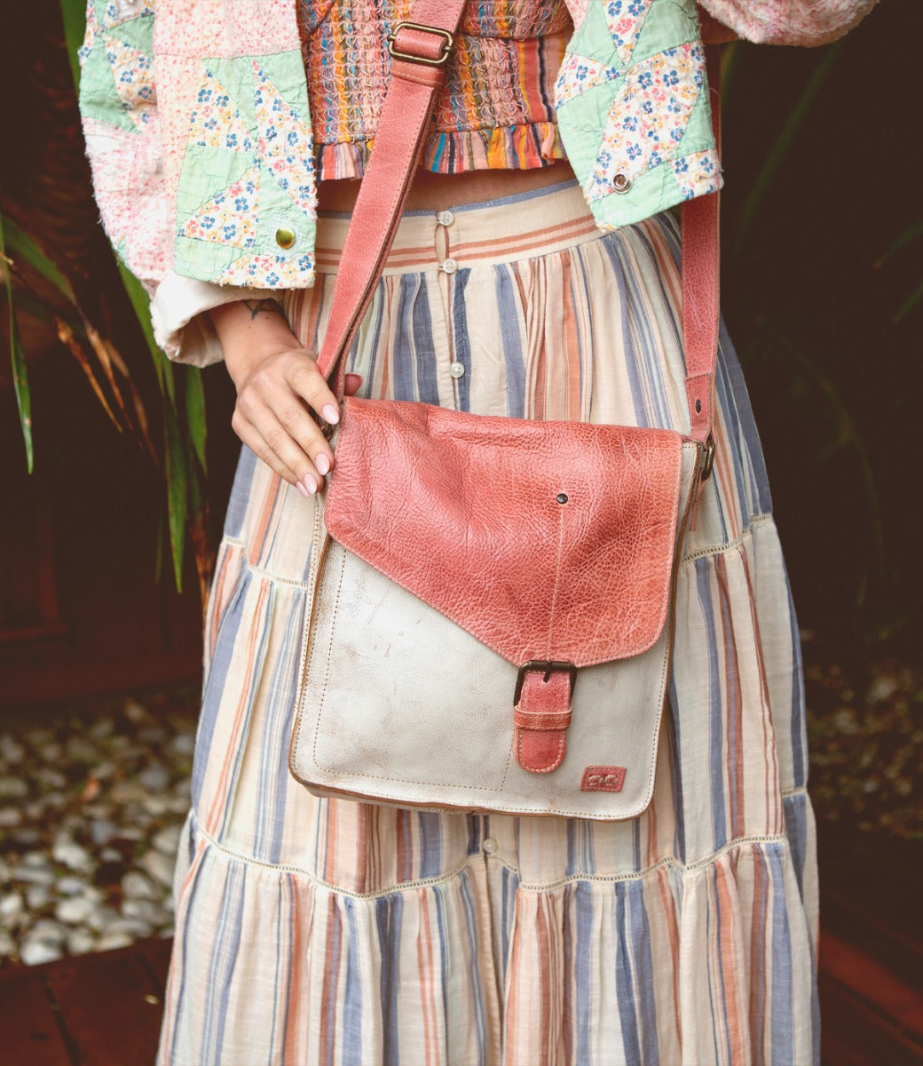 A woman in a striped skirt holding a Venice Beach bag by Bed Stu.