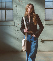 A woman wearing Venice Beach pure leather messenger bag from Bed Stu.