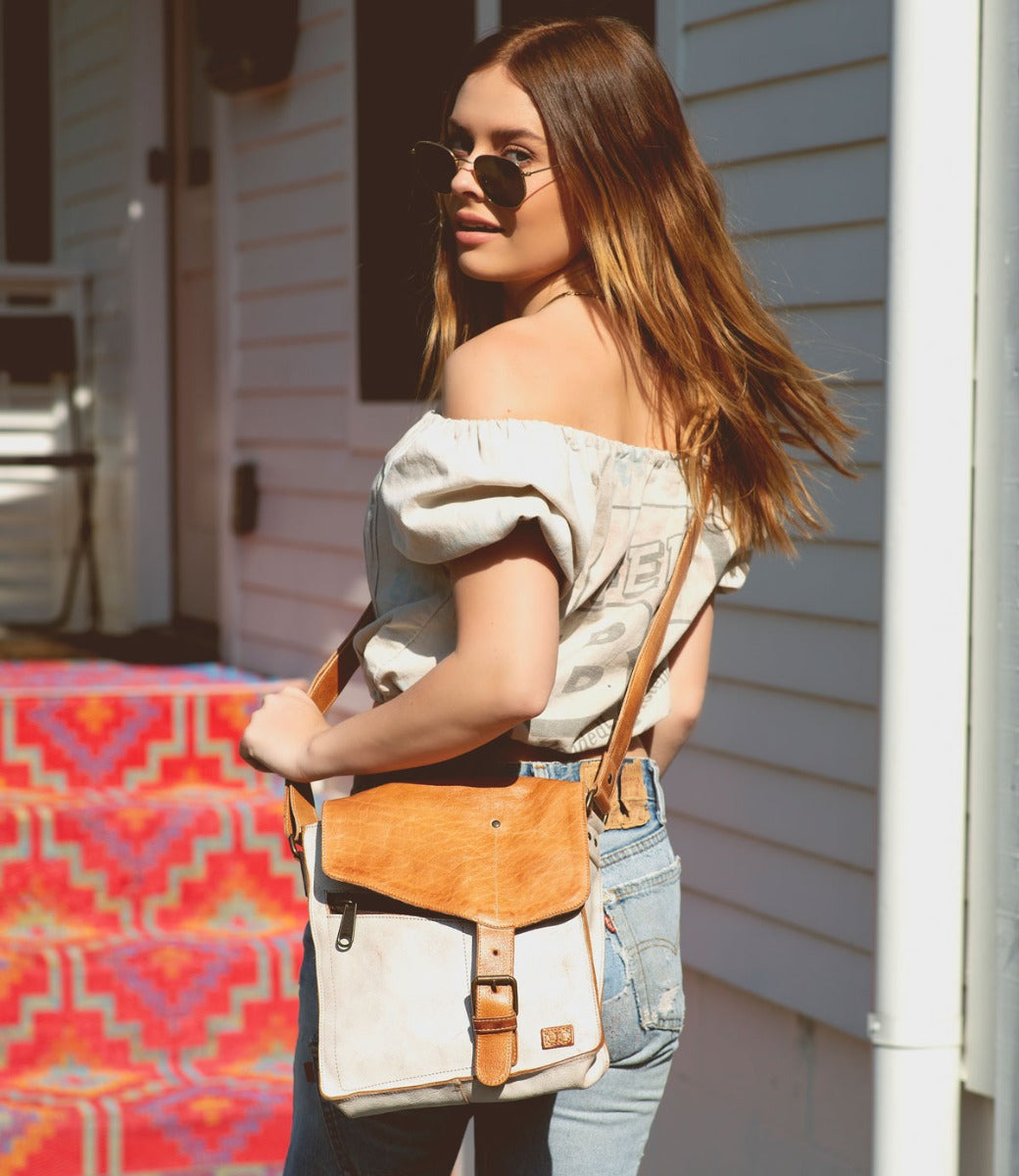 A woman wearing jeans and a Bed Stu Venice Beach leather bag.