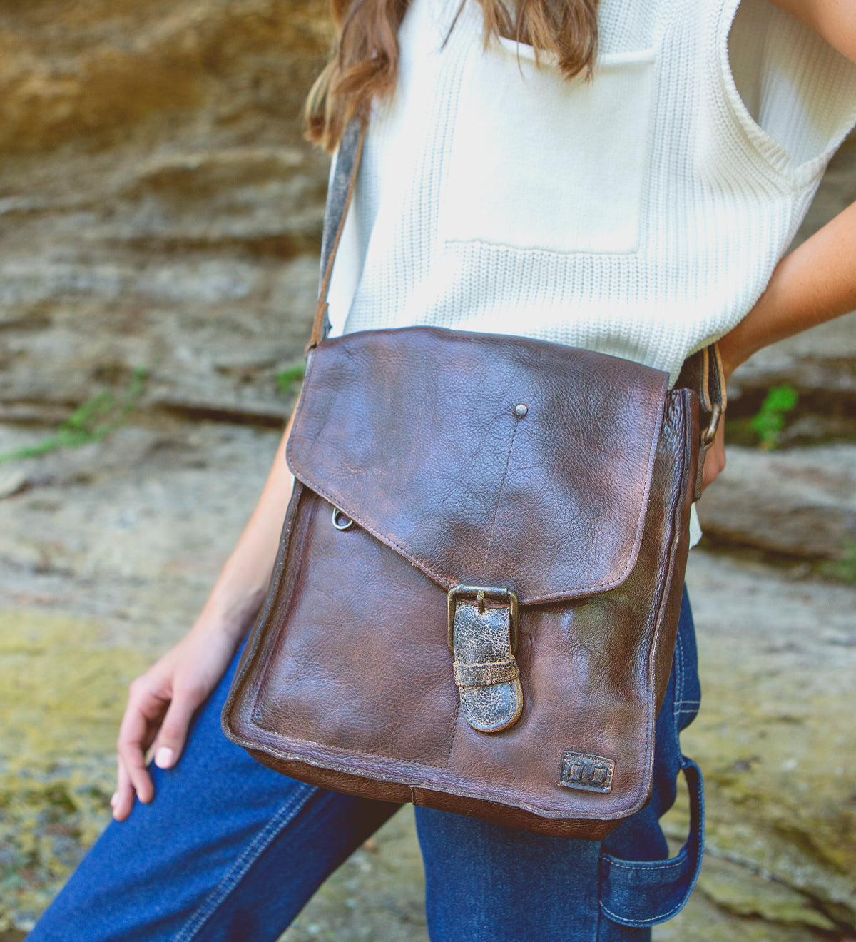 A woman wearing jeans and a Bed Stu Venice Beach teak leather bag.