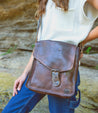 A woman wearing jeans and a Bed Stu Venice Beach teak leather bag.