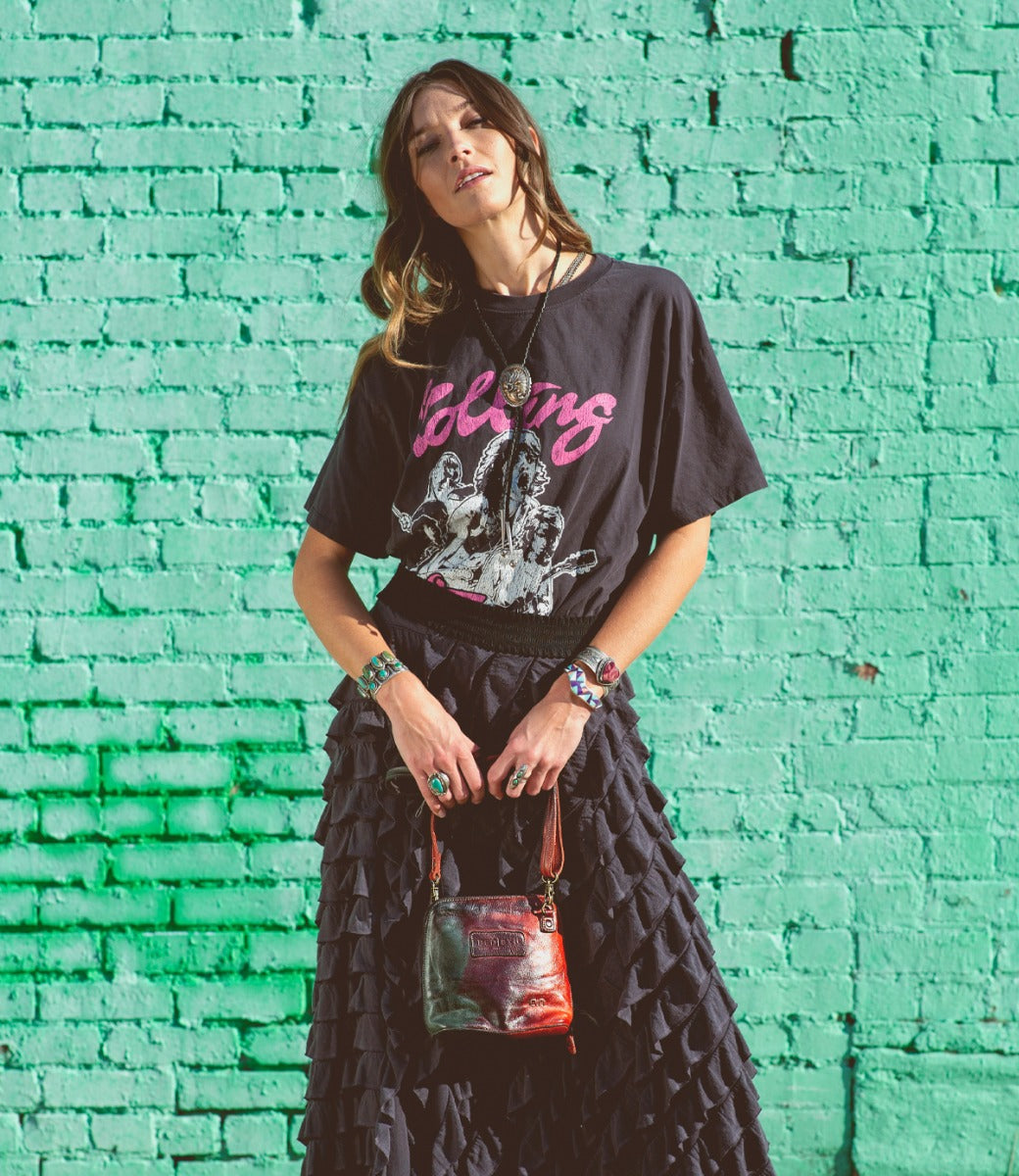 A woman wearing a black Ventura t-shirt and skirt. Brand: Bed Stu.