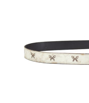 The Wander belt by Bed Stu is crafted from leather, featuring a white outer surface and a black inner lining, adorned with an enchanting design of small butterfly-shaped embellishments.