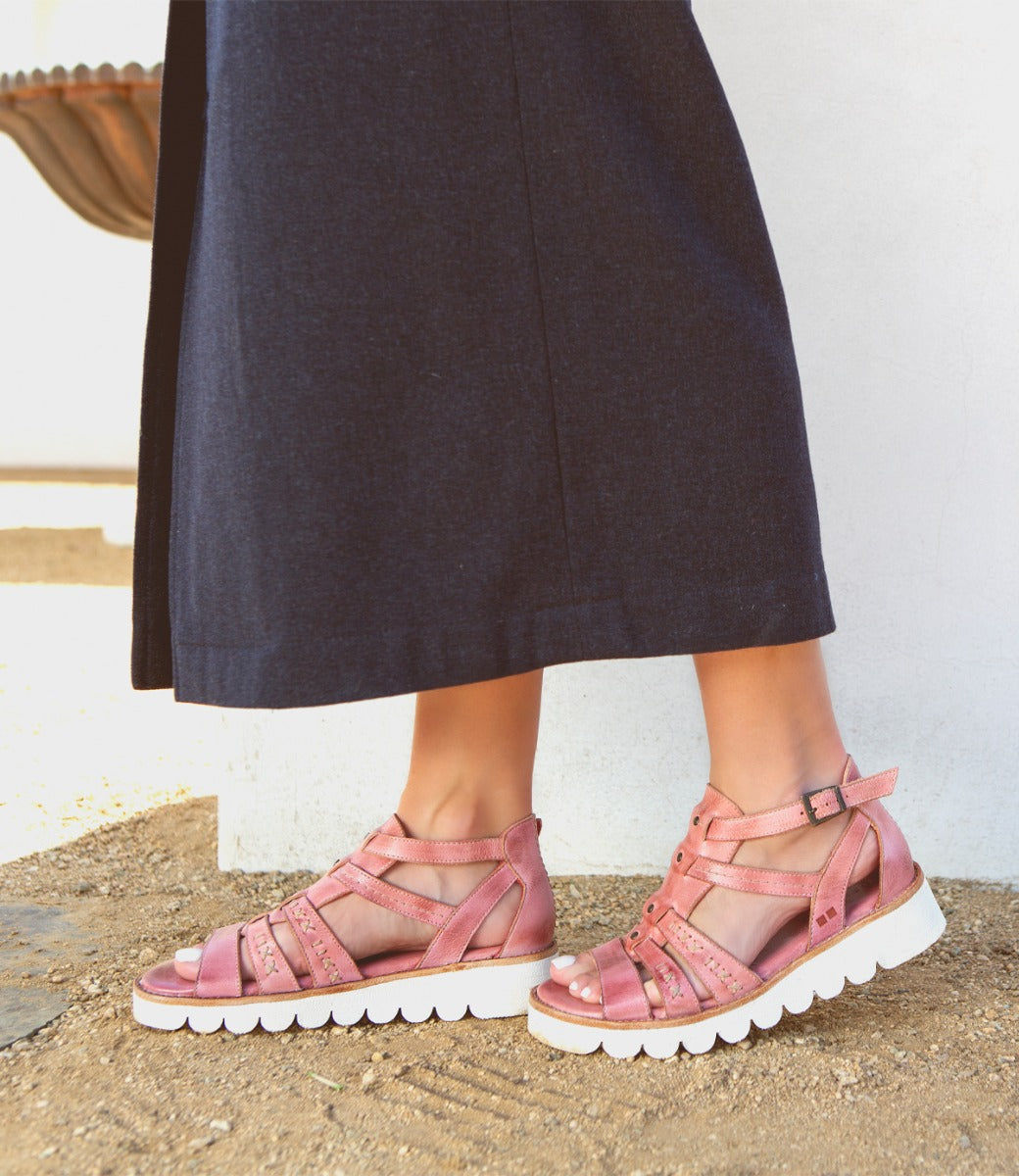 A woman wearing a skirt and Wonder sandals by Bed Stu.