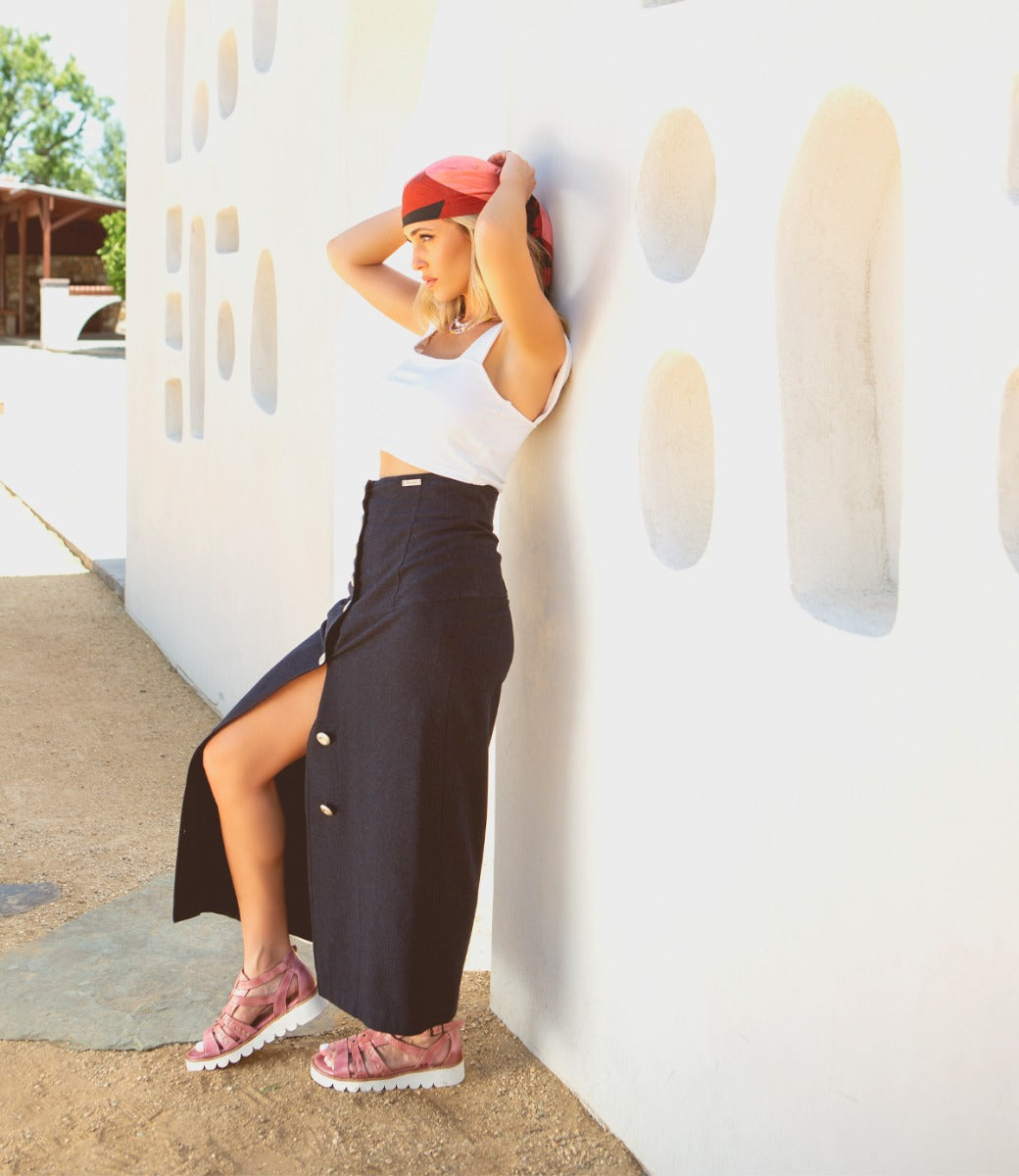 A woman in a black skirt leaning against a wall wearing Wonder by Bed Stu.