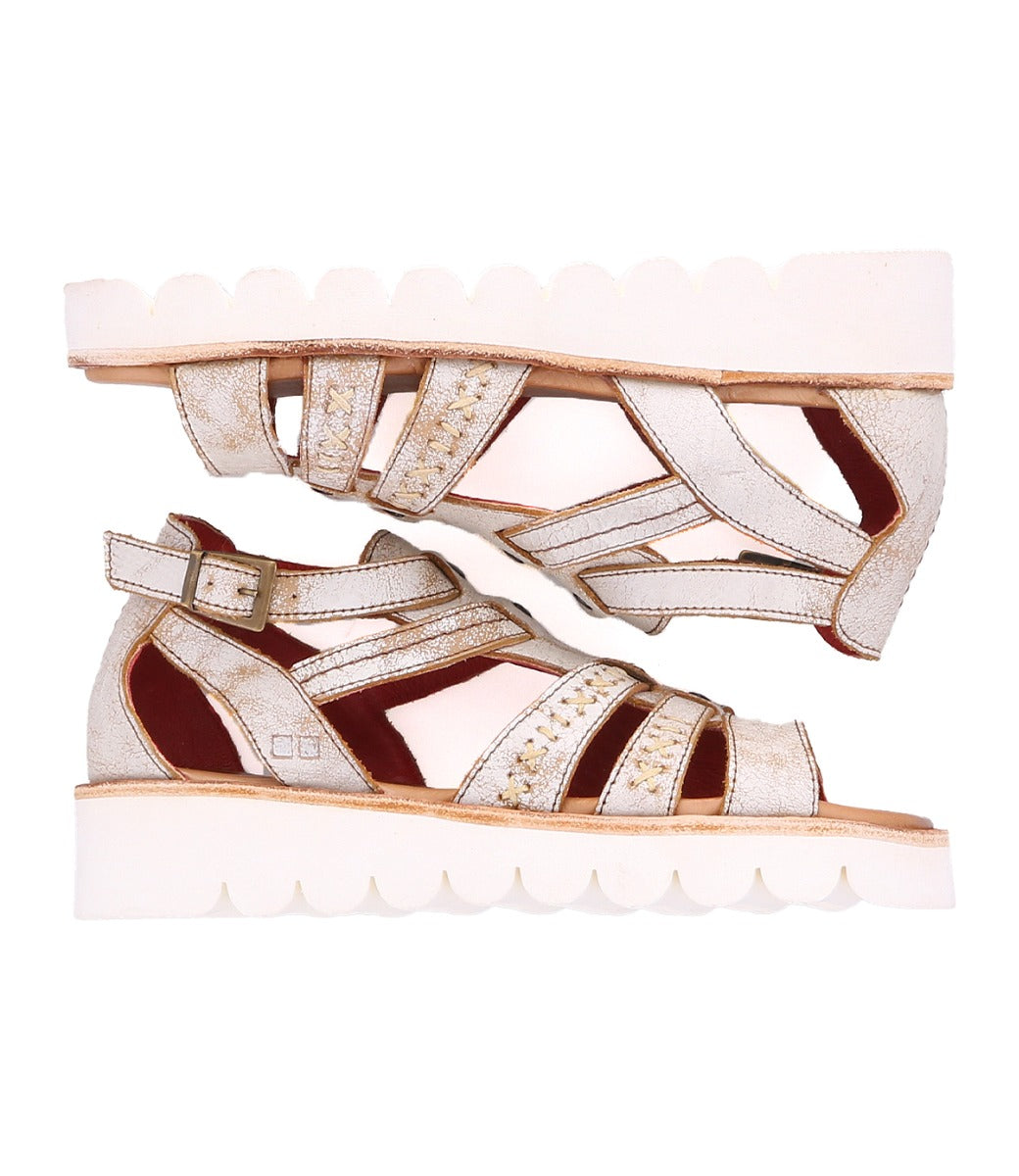 A pair of Bed Stu white sandals with straps and studs, called Wonder.