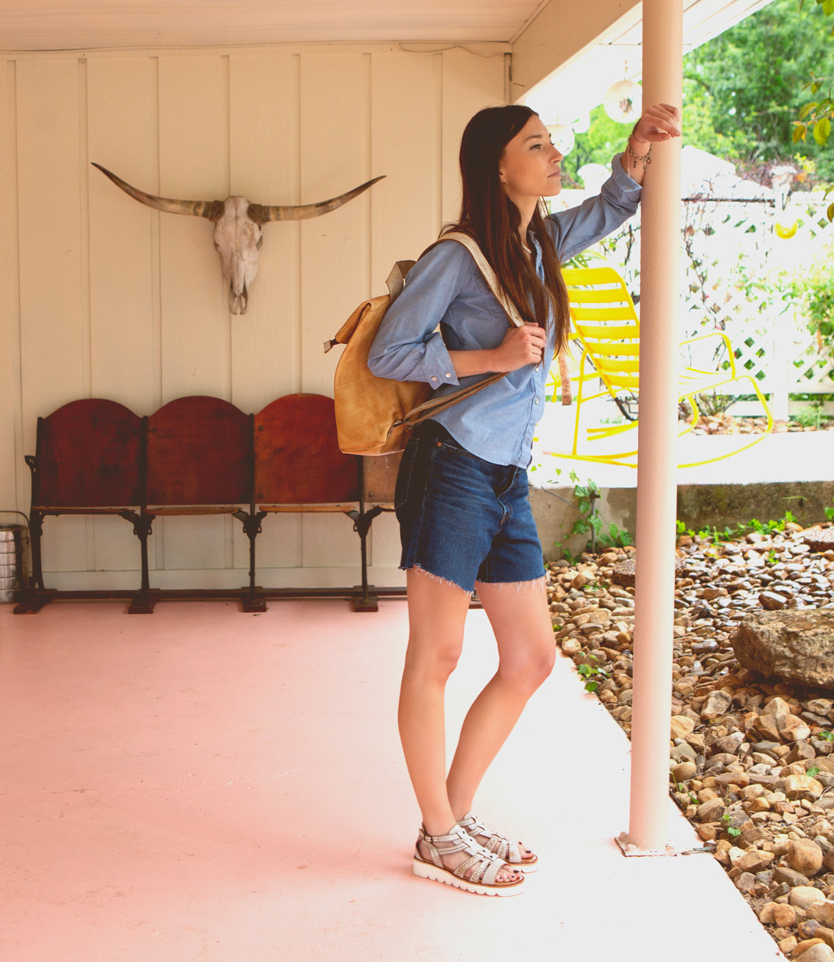 A woman leaning against a pole wearing a pair of Wonder sandals from Bed Stu.