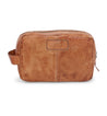 A Bed Stu Yatra brown leather toiletry bag on a white background.