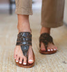 A woman's wearing black Yoli sandals by Bed Stu.