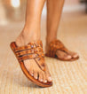 A woman's wearing tan Yoli sandals by Bed Stu.