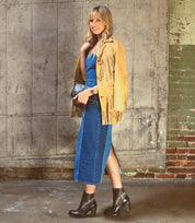 A woman wearing a Yuno denim dress and a Bed Stu tan jacket paired with Bed Stu ankle boots.