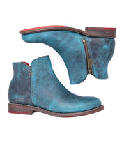 A pair of Yurisa blue ankle boots by Bed Stu, featuring side zippers, Vibram outsoles, and visible stitching details, shown from the top and side views.