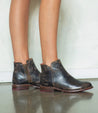A woman wearing a pair of Yurisa black leather chelsea boots by Bed Stu.