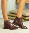 A woman wearing teak leather Yurisa ankle boots by Bed Stu.