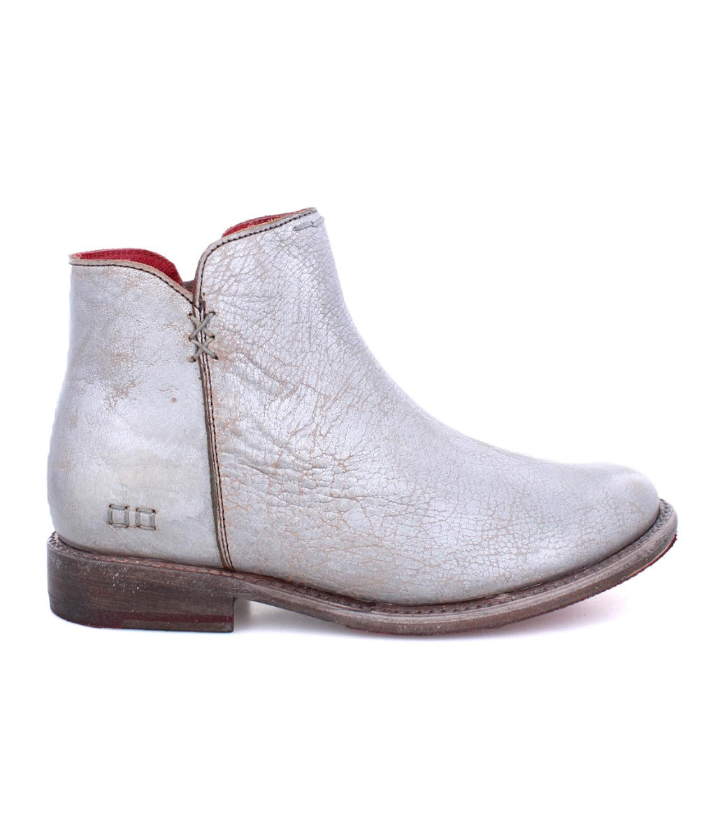A women's Yurisa silver ankle boot by Bed Stu with a red sole.
