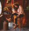 A woman sitting on a stool wearing Bed Stu brown leather boots.