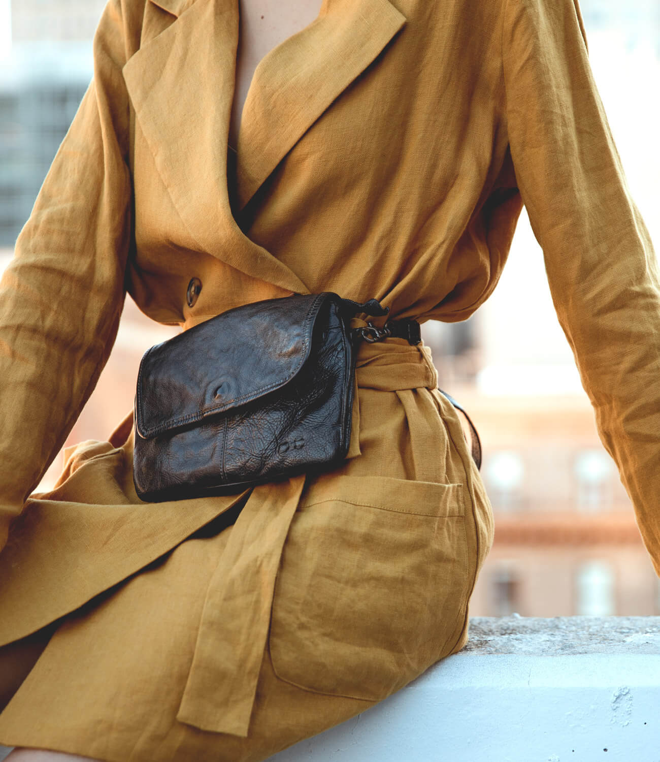 A woman wearing a black Ziggy bag and yellow coat.