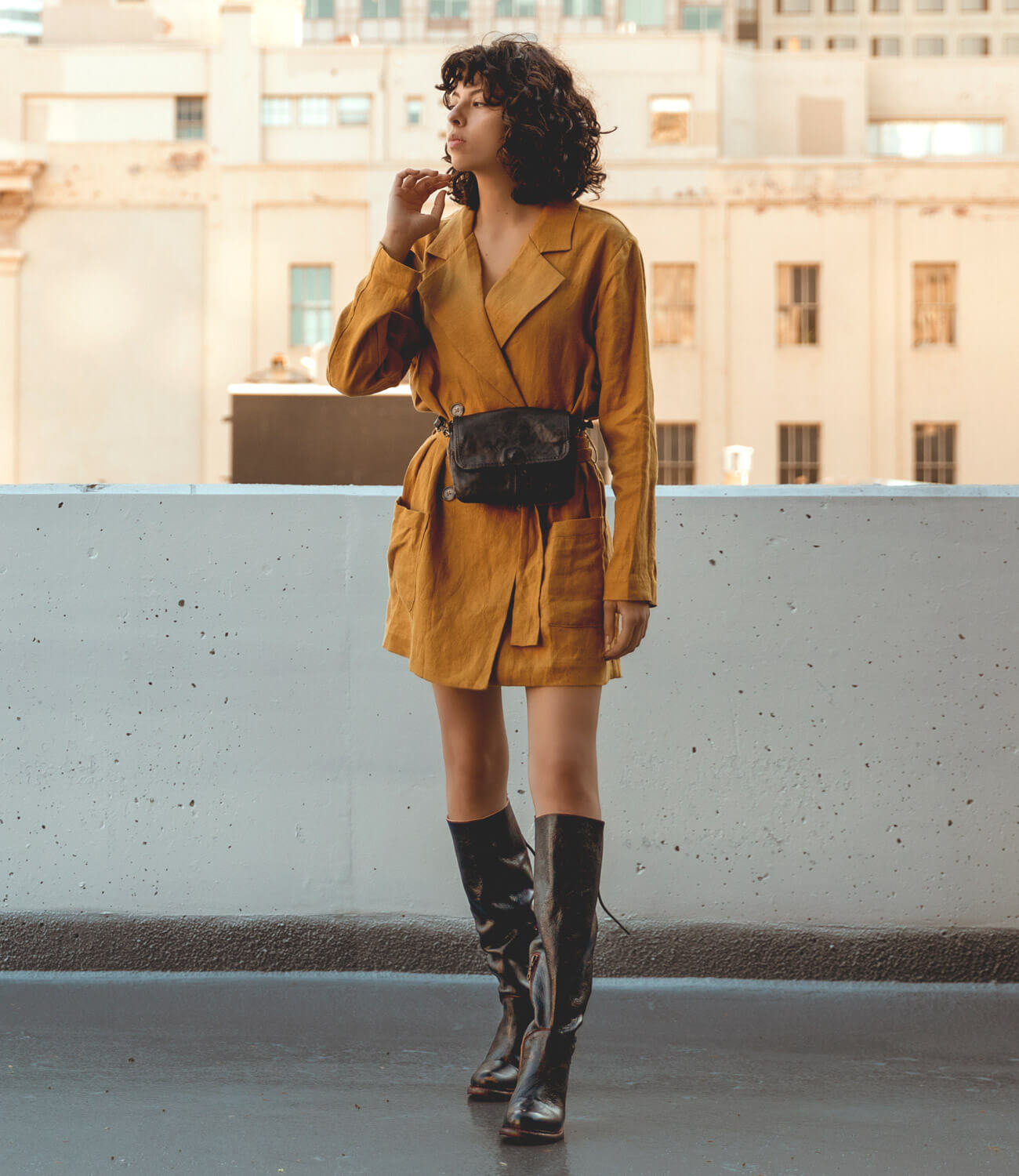 A woman wearing a black Ziggy bag and yellow coat.