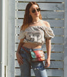 A woman wearing jeans and an off the shoulder top with a Ziggy fanny pack, also known as a belt bag by Bed Stu.