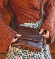 A woman holding a Ziggy by Bed Stu cross body bag.