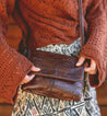 A woman holding a Ziggy by Bed Stu cross body bag.