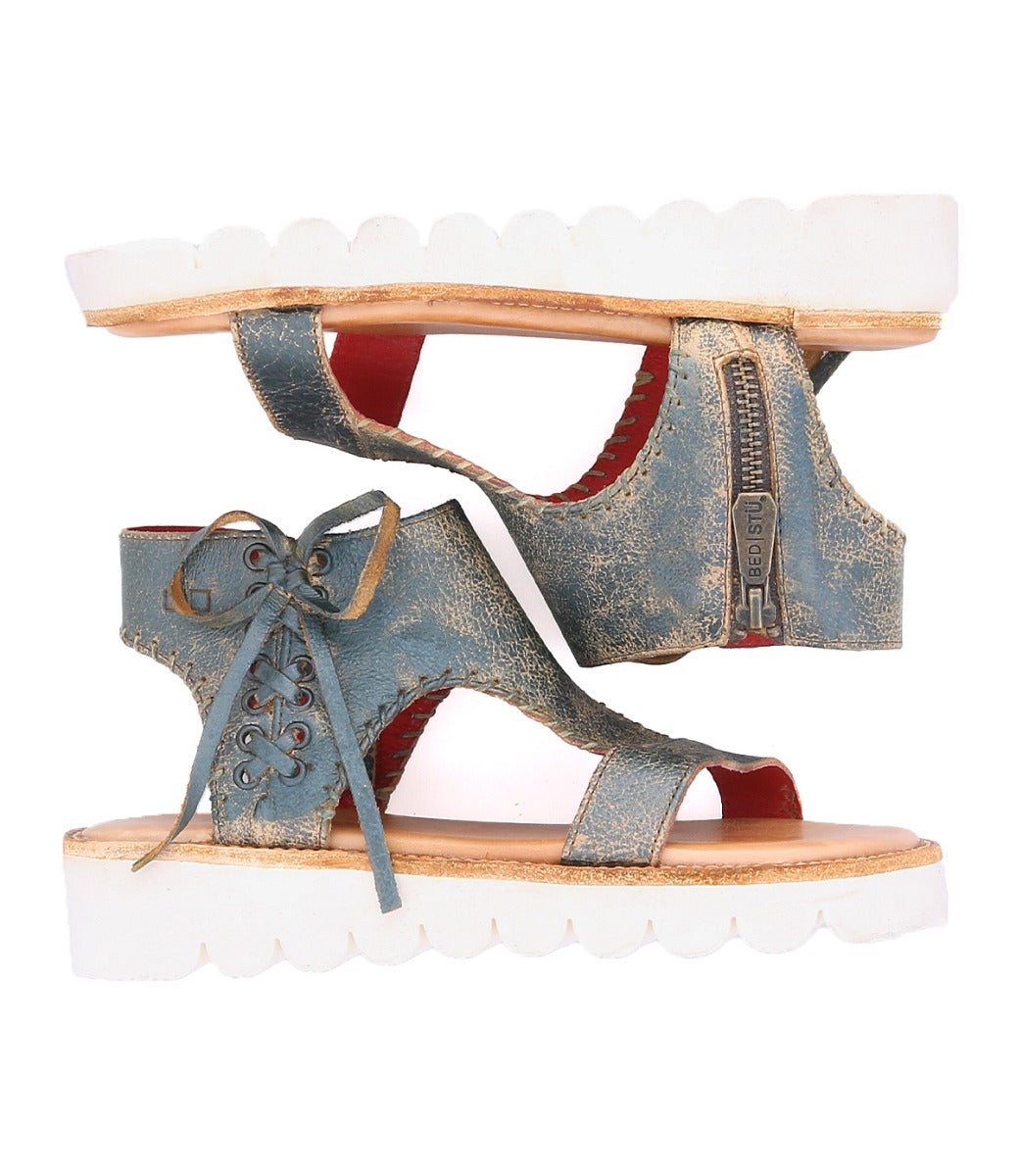 A pair of Bed Stu Zoe II women's blue sandals with white soles.