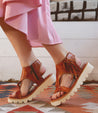 A woman wearing a striped dress and sandals standing on a Bed Stu Zoe II rug.